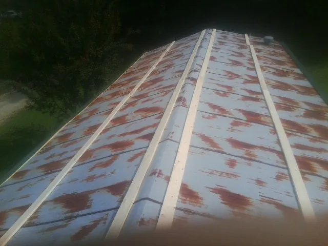 Rusted metal roof panels with new wood purlins before replacement — Storm Damage Roof Repair in Cave Spring by Roofing Brothers
