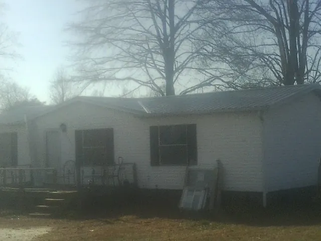 New metal roof on a white painted brick home on a foggy morning in Cave Spring