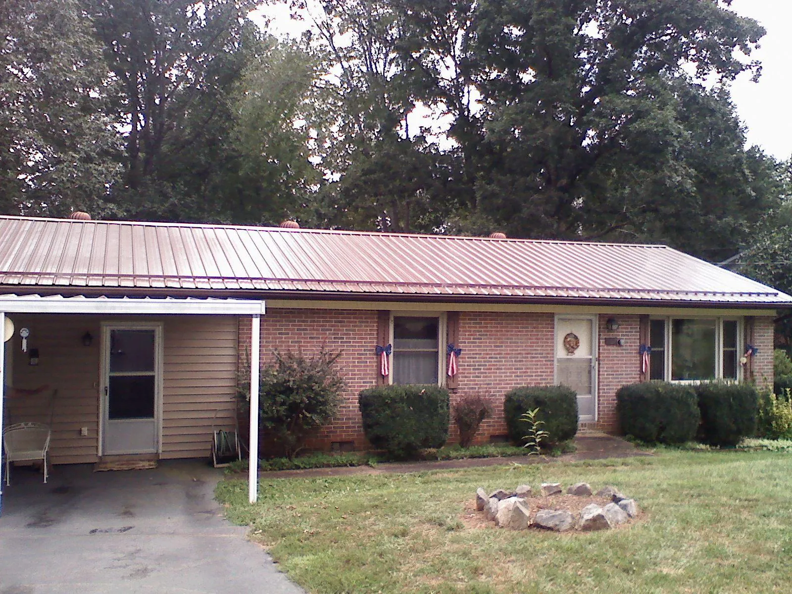 Bronze metal roof and carport on a brick ranch home — Roof Repair work by our crew in Cave Spring